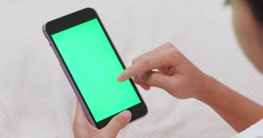 Smartphone ile yatakta Kroma anahtar kullanan kadın