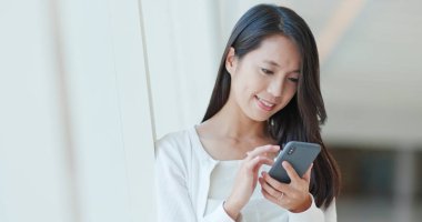 Alışveriş merkezinde cep telefonu kullanan kadın