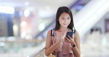 Cep telefonu kullaranarak ve kameraya bakarak kadın