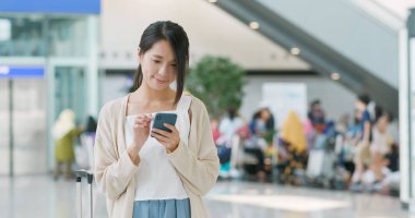 Havaalanında cep telefonu kullanan kadın