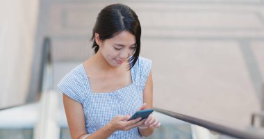 Yürüyen merdiven telefon kullanan kadın