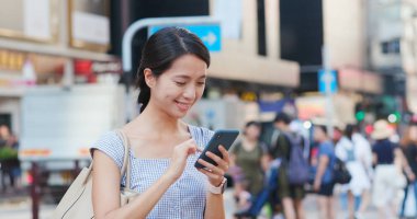 Sokağın konumda aramak için cep telefonu kullanan kadın