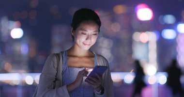 Şehirde akıllı telefon kullanan bir kadın