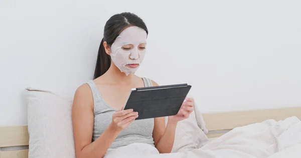 Vrouw Toepassen Gezichtsmasker Kijken Tablet Thuis — Stockfoto