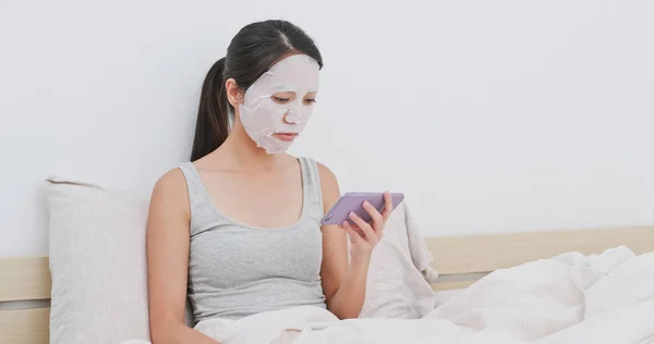 Perempuan Menerapkan Masker Kertas Tempat Tidur Dan Menggunakan Ponsel — Stok Foto