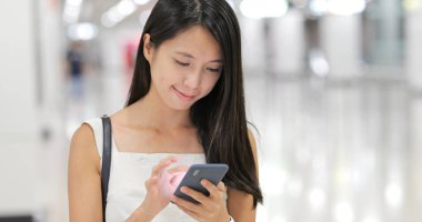 İstasyonda sms göndermek için cep telefonu kullanan kadın