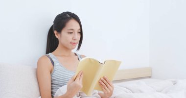 Kadın okuma kitap ve yatağa otur