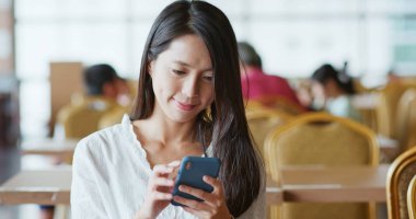 Kahve dükkanında Smartphone kullanan kadın