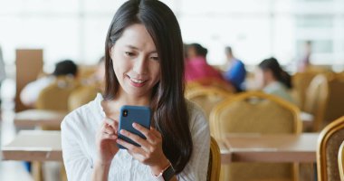 Kahve dükkanında Smartphone kullanan kadın