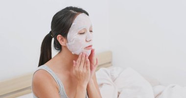 Evde kağıt maske kullanan kadın