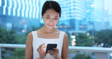 Gece akıllı telefon kullanan bir kadın.