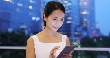 Geceleri cep telefonu kullanan bir kadın.