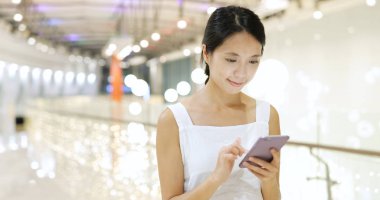 alışveriş merkezinde cep telefonu kullanan kadın