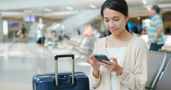 空港での携帯電話上の便を確認する女性 — ストック写真