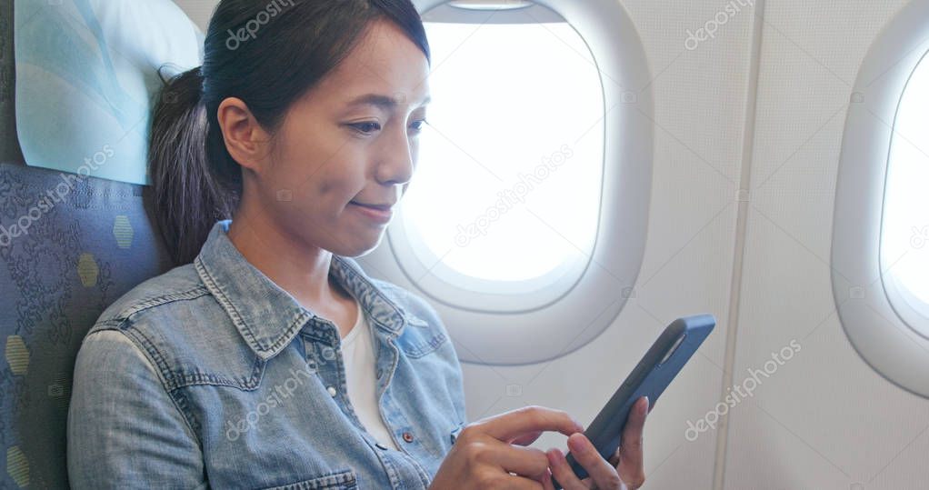 Woman look at the cellphone on plane