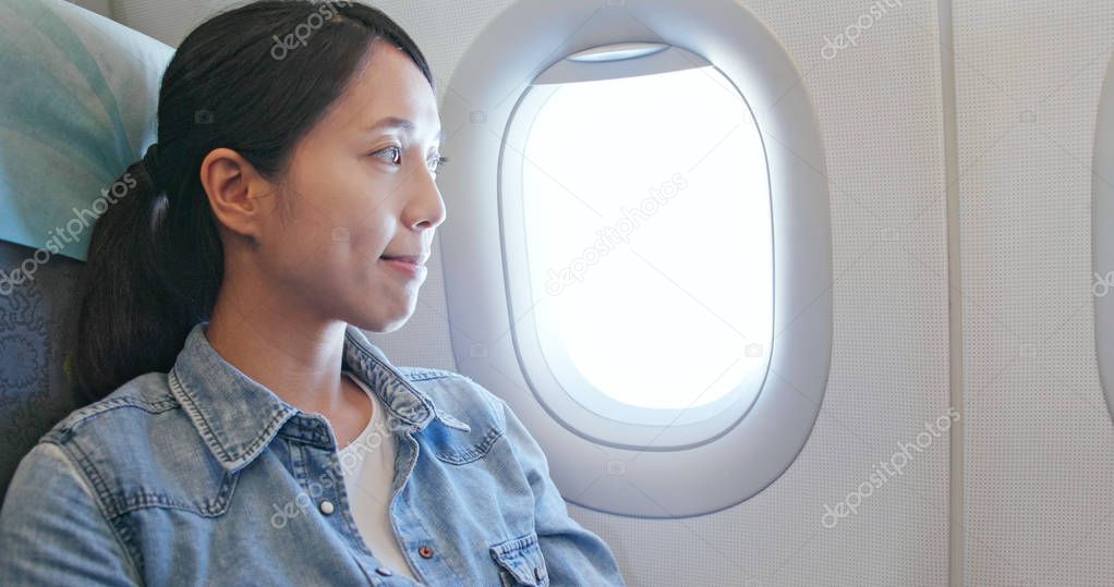 Woman looking out of window on plane