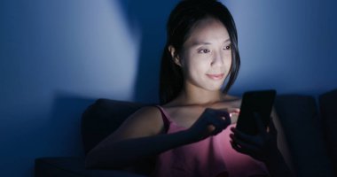 Cep telefonuyla kanepede geceleri kadın