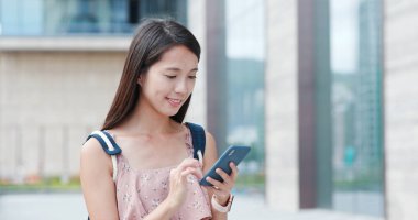 Şehirde akıllı telefon kullanan bir kadın.