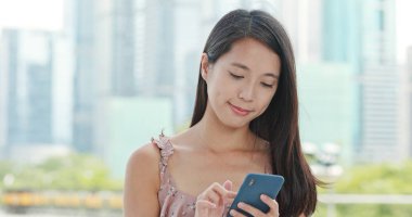 Şehirde akıllı telefon kullanan bir kadın.