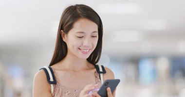 Cep telefonu ile alışveriş merkezi arka plan bulanıklık kullanan kadın