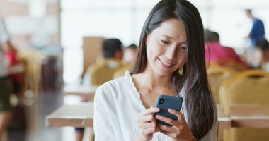 Kahve dükkanında Smartphone kullanan kadın