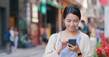 Sokağın konumda aramak için cep telefonu kullanan kadın