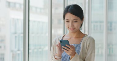 Asya alışveriş merkezi içinde smartphone kullanan kadın