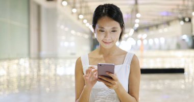 Alışveriş Merkezi içinde cep telefonu kullanan kadın