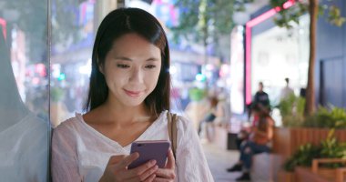 Cep telefonu şehirde geceleri kullanan kadın