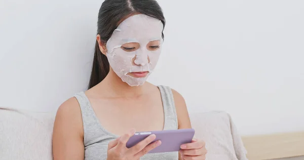 Vrouw Papier Masker Toepassen Bed Gebruik Mobiele Telefoon — Stockfoto
