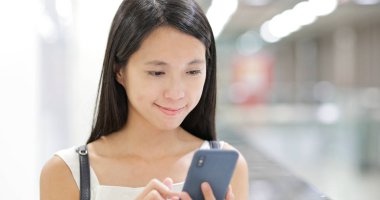 İstasyonda cep telefonu kullanan kadın