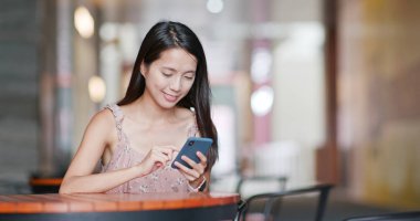 Cep telefonu açık kahve dükkanında kullanan kadın