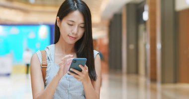 Alışveriş merkezinde Smartphone kullanan kadın