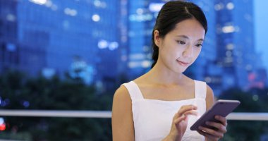 Gece akıllı telefon kullanan bir kadın.