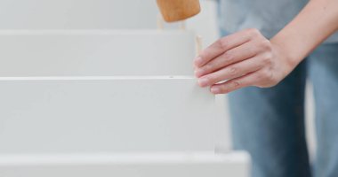 Kadın evinde raf monte ediyor. 