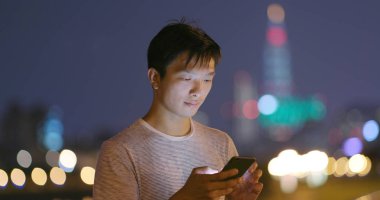 Geceleri cep telefonu kullanan adam