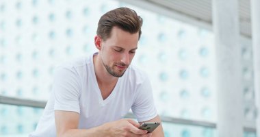 Beyaz adam şehir cep telefonu üzerinde çalışıyor