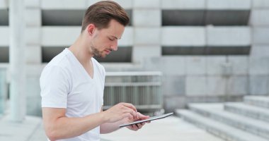 Beyaz adam şehirde tablet bilgisayar kullanarak