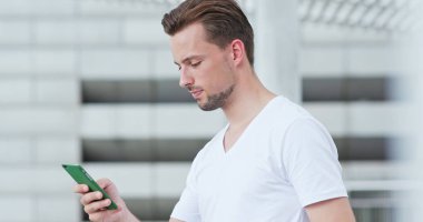 Beyaz adam cep telefonuyla şehirde