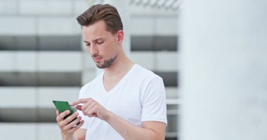 Beyaz adam cep telefonuyla şehirde