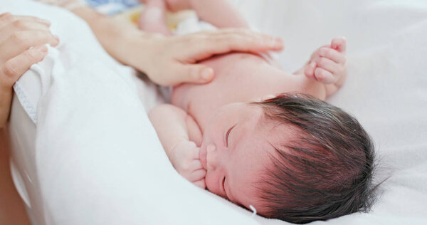 New born baby crying with mother hand comforting