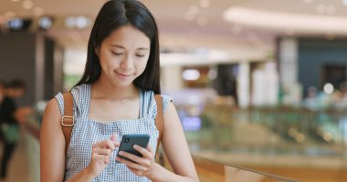 Alışveriş merkezinde Smartphone kullanan kadın