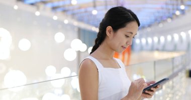 Alışveriş Merkezi içinde cep telefonu kullanan kadın