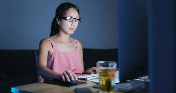 Woman working on computer at night and feeling eye dry