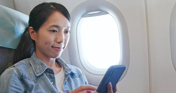 Жінка Дивиться Мобільний Телефон Літаку — стокове фото