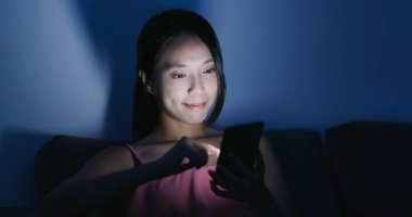 Cep telefonuyla kanepede geceleri kadın