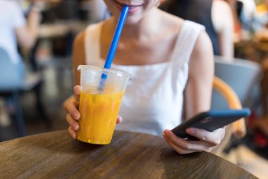 Kahve Dükkanı içinde sulu ve kullanma cep telefonu bardak içme kadın