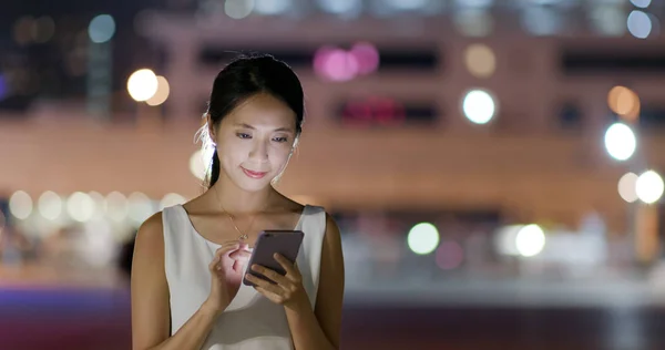 Woman read on cellphone at night