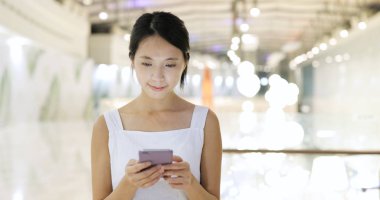 Alışveriş Merkezi içinde cep telefonu kullanan kadın