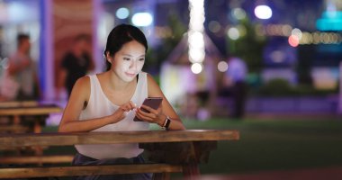 Açık café'de cep telefonu kullanan kadın